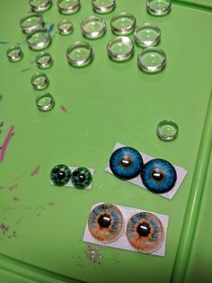 an assortment of glass beads and eyeballs on a green table