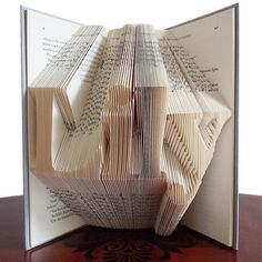 an open book with pages folded in the shape of a boat on top of it