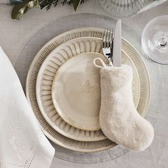 a white plate topped with a christmas stocking next to a silver fork and knife