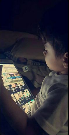 a young boy sitting in front of a laptop computer