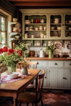 a wooden table topped with lots of flowers next to a kitchen filled with pots and pans