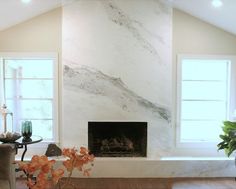 a living room filled with furniture and a fire place in front of a stone fireplace