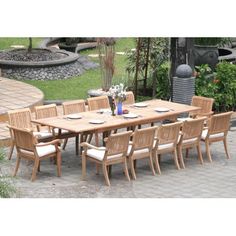 an outdoor dining table and chairs set up on a patio with flowers in vases