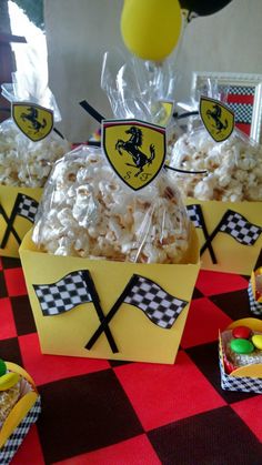 some yellow boxes filled with popcorn on top of a red and black checkered table cloth