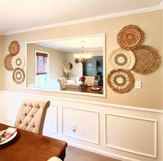 a dinning room table and chairs with plates on the wall in front of it