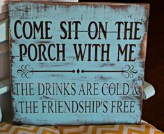 a wooden sign that says, come sit on the porch with me the drinks are cold and the friends free