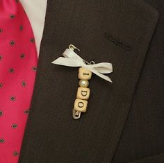 a person wearing a suit and tie with wooden blocks attached to his lapel pin