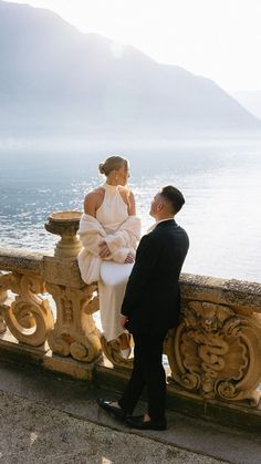 a man standing next to a woman on top of a balcony