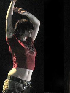 a woman in red shirt and black shorts on stage