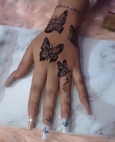 a woman's hand with butterfly tattoos on it