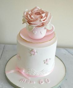 a white and pink cake with a rose on top