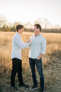 two men standing next to each other in a field