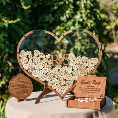 a heart shaped wooden box with wedding guest book on it and two small boxes in the shape of hearts