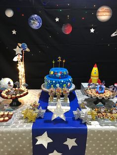 a space themed birthday party with cake and desserts