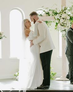 a bride and groom standing in front of the alter at their wedding ceremony with white flowers