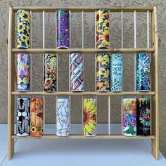 a wooden shelf with many different colored cans on it's sides and the bottom section is made out of wood