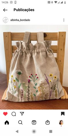 a bag with flowers on it sitting on top of a wooden chair