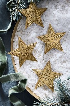 three gold star ornaments sitting on top of white rice