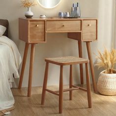 a bedroom with a vanity and stool next to a mirror on the wall, in front of a bed