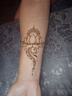 a woman's arm with a henna tattoo on it