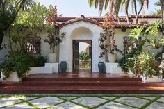 an entrance to a house with potted plants on either side and steps leading up to the front door