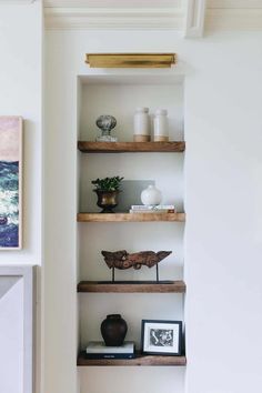 some shelves with pictures and vases on them