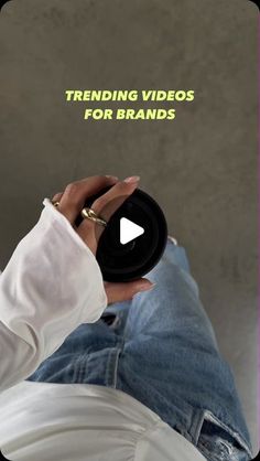 a person holding a black object with the words trending videos for brands