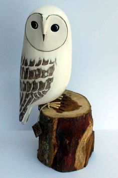 an owl figurine sitting on top of a tree stump