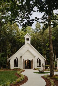 a white church surrounded by trees and grass