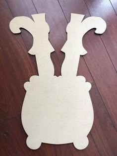 a cut out of paper sitting on top of a wooden floor