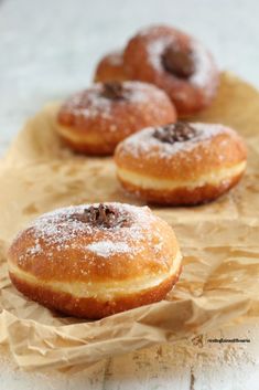 three donuts sitting on top of brown paper