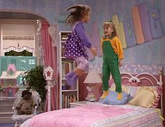 two children jumping on a bed in a bedroom