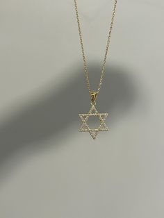 Dainty and so sparkly, perfect for everyday wear! Information: ✨Sterling Silver (925 stamped) | 14K Gold Plated ✨High quality AAA Cubic Zirconia gemstones ✨Adjustable length: 16" - 18" ✨Hypoallergenic ✨Tarnish resistant Our Star of David necklace is minimalist and so elegant. The necklace is made with a high grade of craftsmanship and attention to detail, each stone is highly polished for a strong sparkle. The charm measures 3/4" by 3/4". The necklace is adjustable from 16" to 18", allowing you to find the perfect fit and create multiple layering styles. Our necklace makes a perfect gift! Star Of David Necklace, Jewish Star, Star Charm Necklace, Layered Fashion, Gold Charm Necklace, Diamond Star, Star Of David, Star Charms, Gold Stars