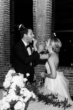 a bride and groom feeding each other cake