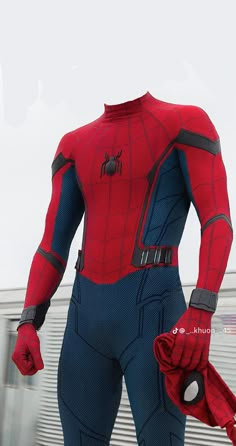 a man in a spider - man suit is standing outside