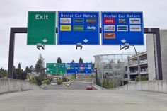 an exit sign above a highway with cars driving on it