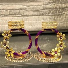 two gold and purple bracelets with flowers on them