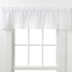 a white window curtain with ruffled edges