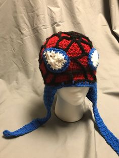 a crocheted spiderman hat on top of a white mannequin head