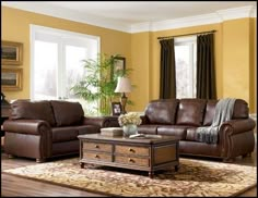 a living room with two couches, a coffee table and a rug on the floor