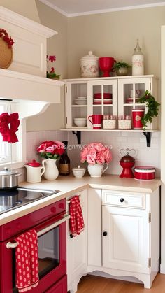 a kitchen with red and white accessories on the counter tops, cabinets, and drawers