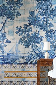 a room with blue and white wallpaper that has a bench in front of it