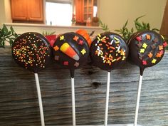 four chocolate cake pops with sprinkles on them