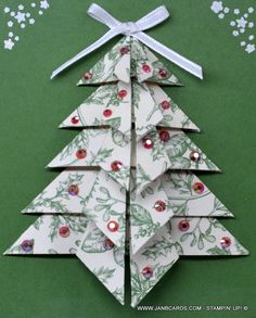 an origami christmas tree on a green background