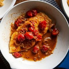 two white bowls filled with food on top of a table