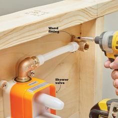 a person holding a drill and screwdriver in front of a wooden shelf with other tools attached to it