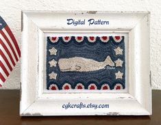 an old white frame with a blue whale and stars on it next to the american flag