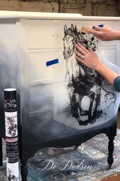 someone is painting a horse on the side of a mailbox with black and white paint