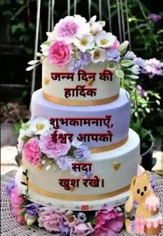 a three tiered cake with flowers on the bottom and words in english written on it