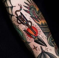 an arm with some tattoos on it and a knife in the middle, surrounded by other items